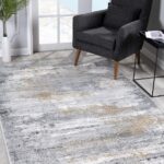 Gray armchair, abstract rug in bright room.