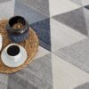 Tea set and candle on woven mat.