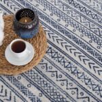Blue patterned rug with candle and coffee cup