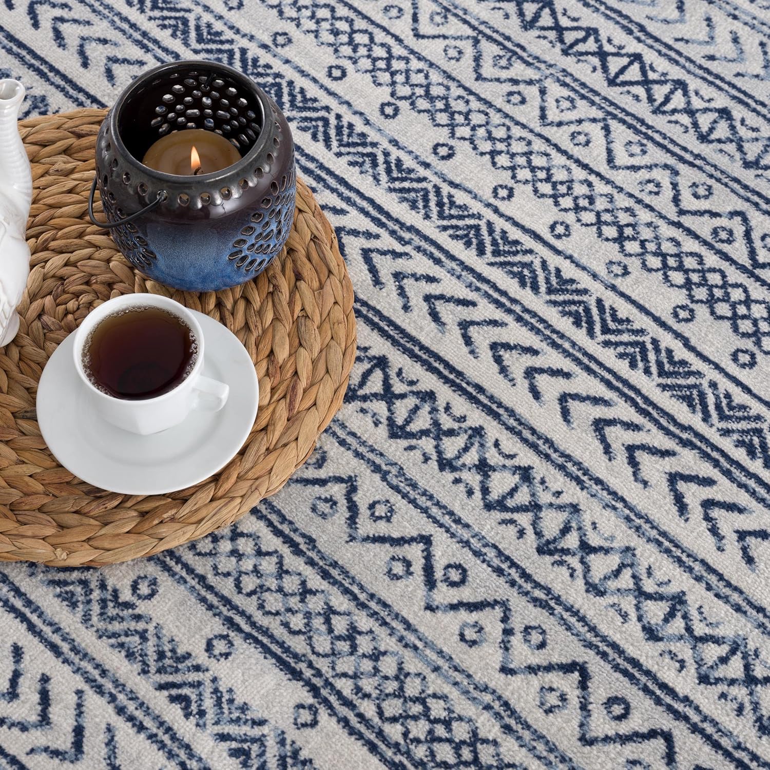Blue patterned rug with candle and coffee cup