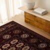 Traditional rug on wooden floor near table