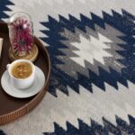 Coffee on tray with open book and flowers.