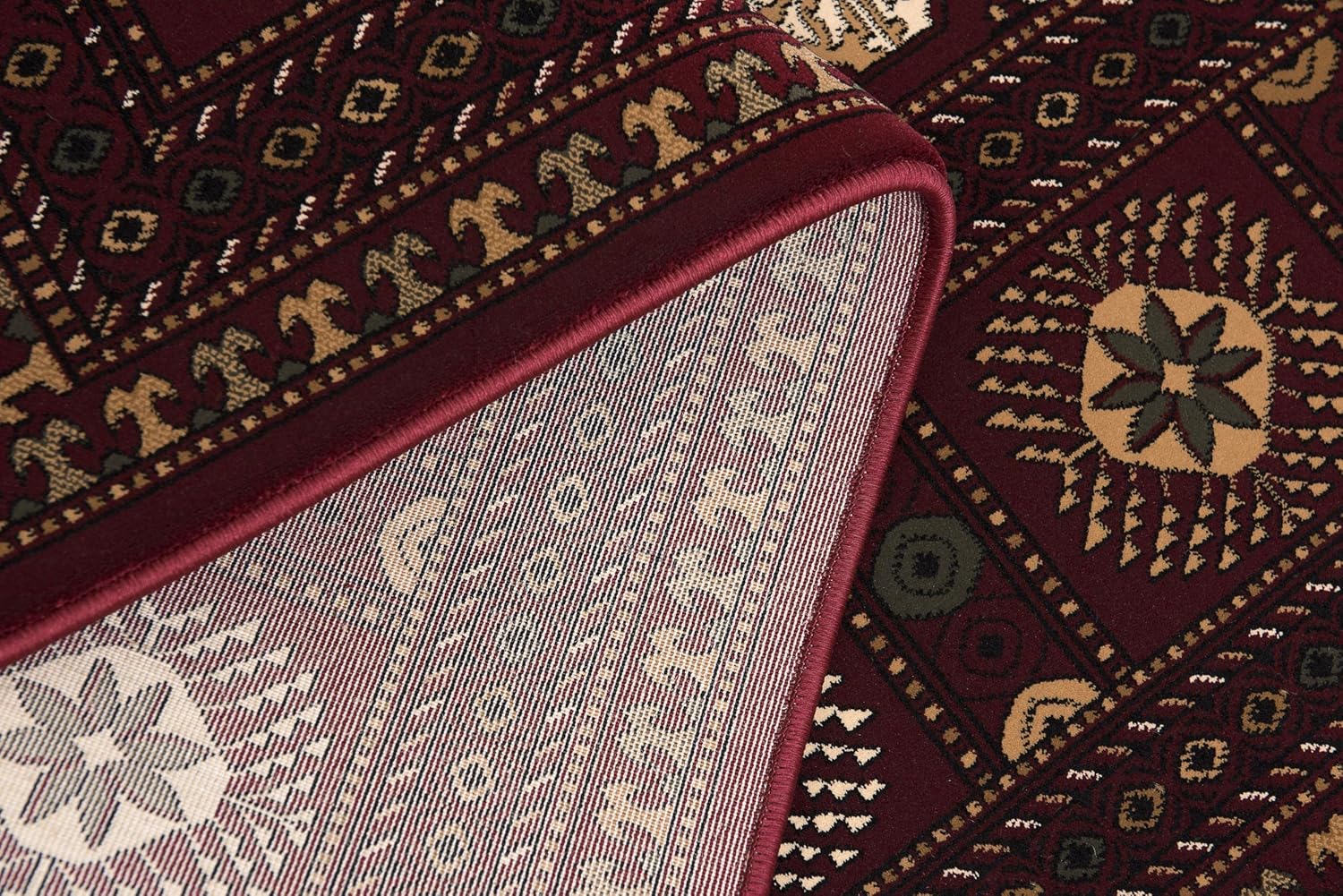 Close-up of folded maroon patterned rug.