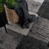 Cozy blanket in basket on patterned carpet