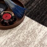 Decorative tray with teapot and book on carpet