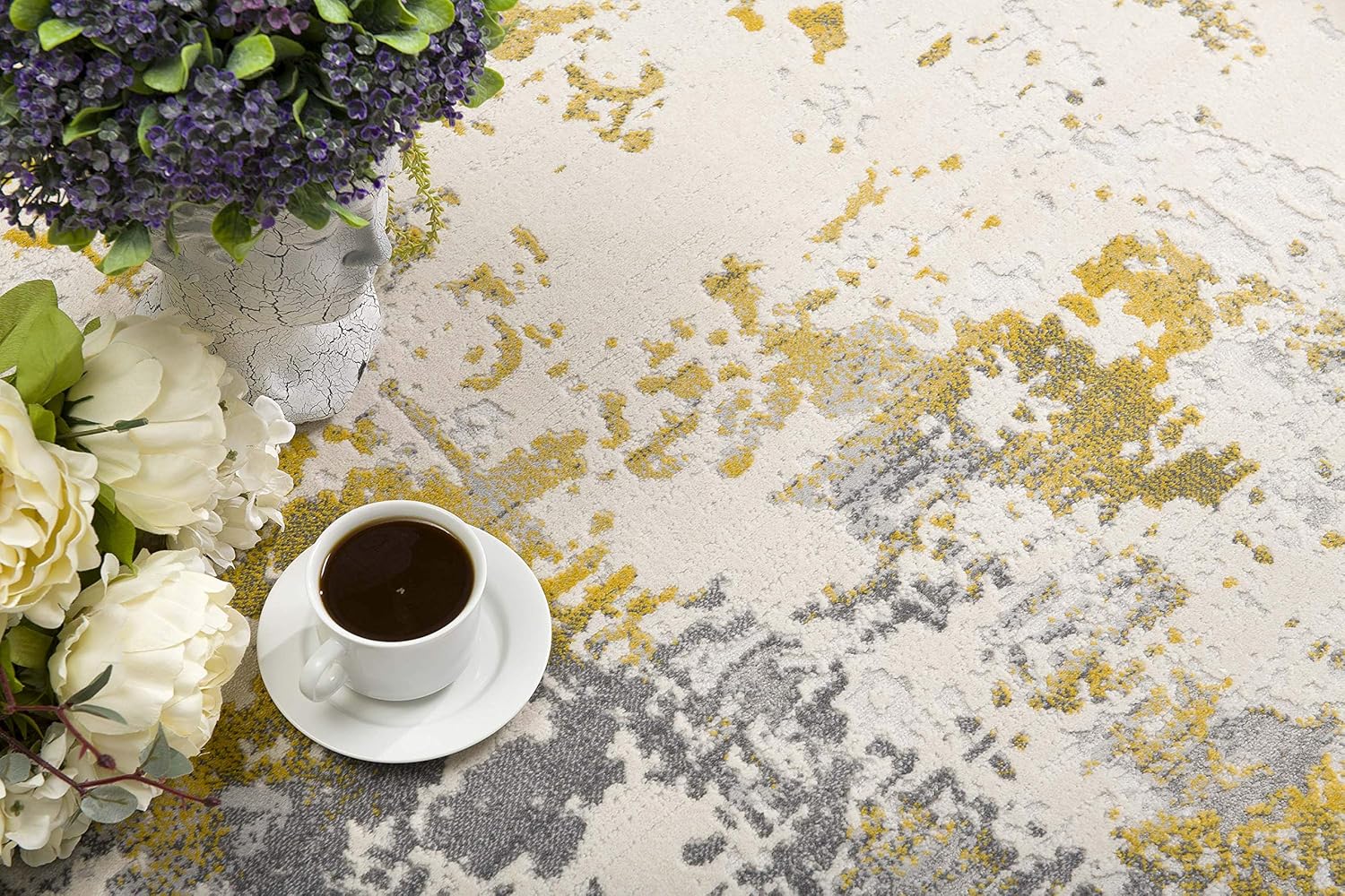 Coffee and flowers on abstract rug.
