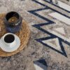 Tea set and candle on patterned rug.