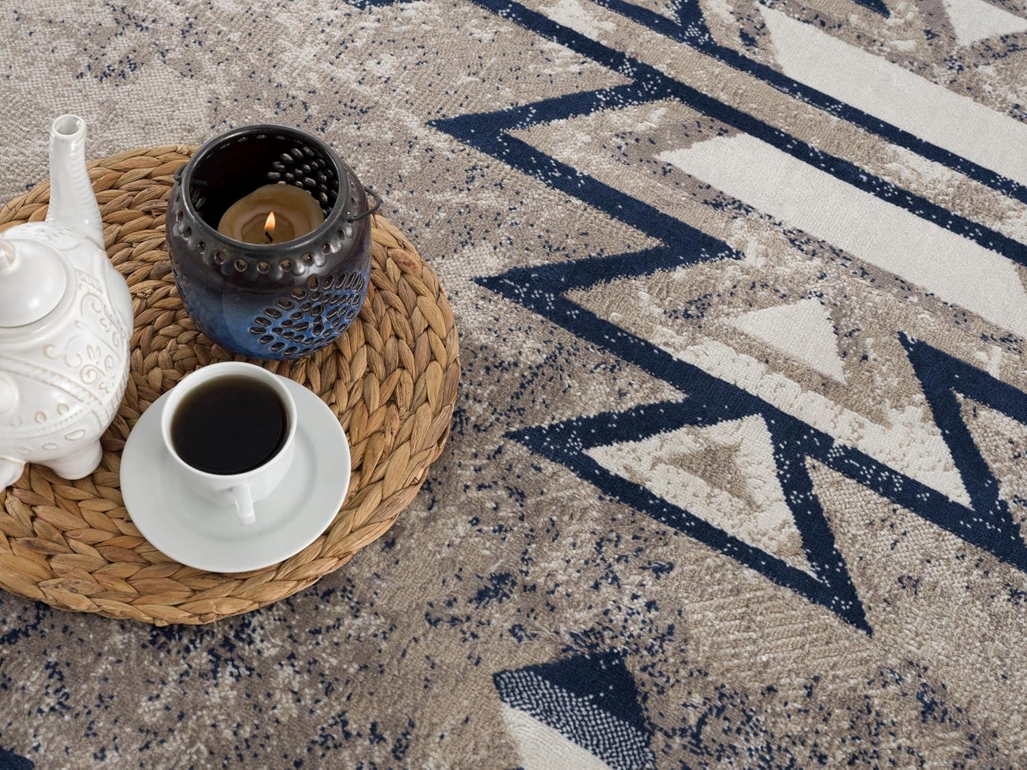 Tea set and candle on patterned rug.