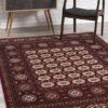 Red patterned rug, chair, and cabinet in room.