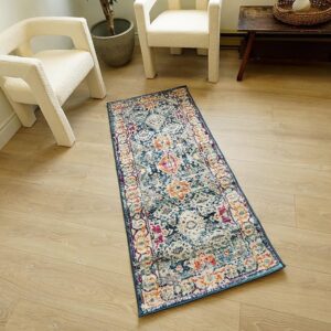 Colorful runner rug on wooden floor between chairs.