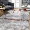 Modern living room with abstract rug and gray chair.