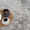 Tea set and candle on woven mat.
