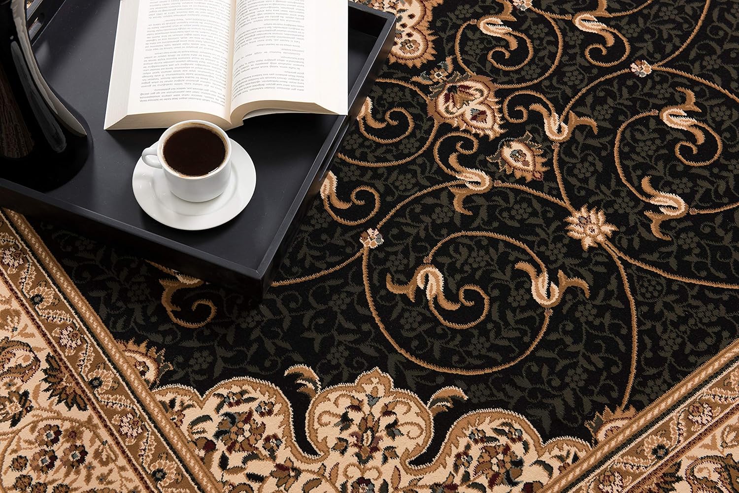 Ornate rug with coffee and book on tray.