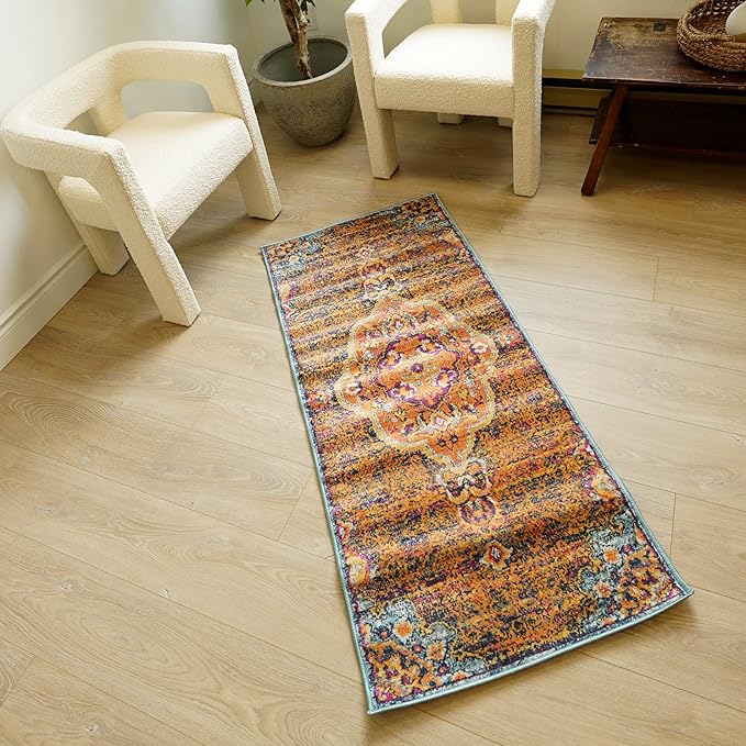 Patterned rug between cream chairs on wooden floor.