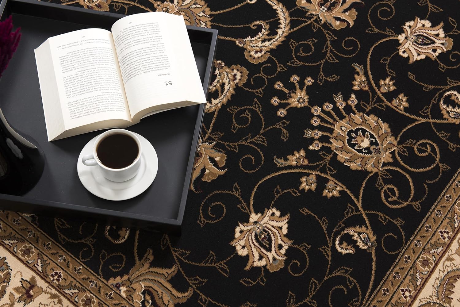 Coffee and book on floral patterned carpet