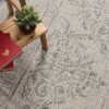 Table with books and plant on patterned carpet