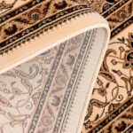 Detailed close-up of ornate beige carpet pattern.