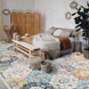 Cozy bedroom with boho decor and colorful rug.