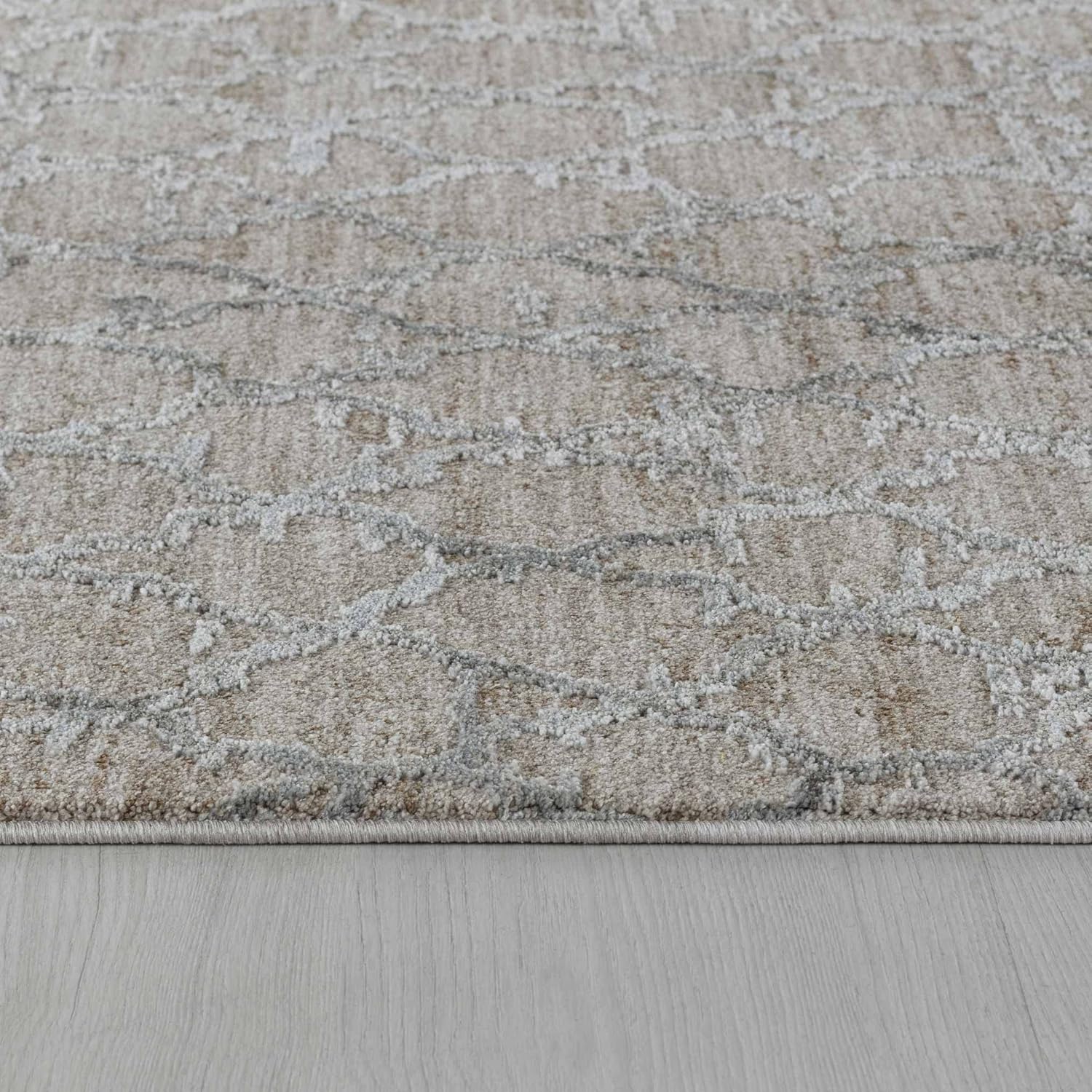 Gray patterned rug on wooden floor.