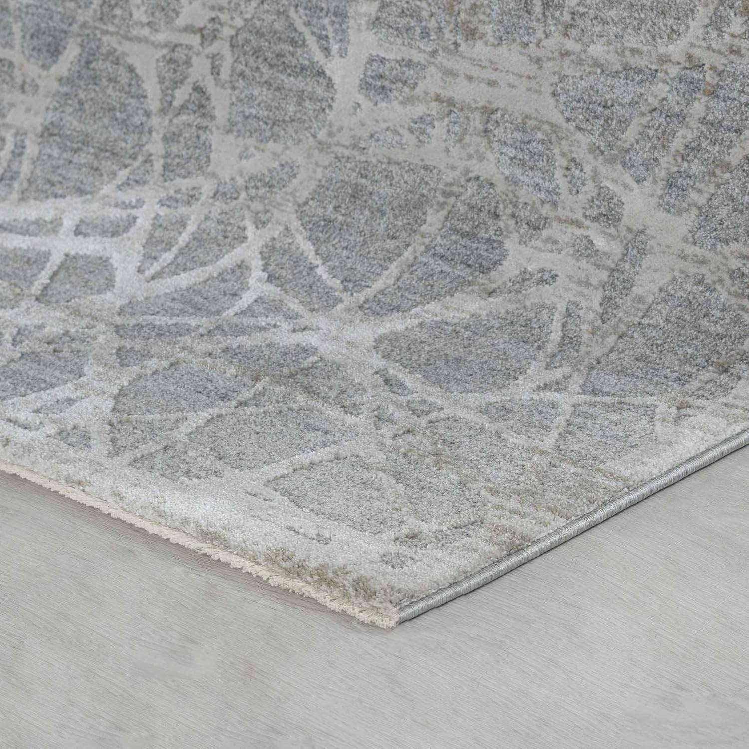 Abstract patterned gray rug on wooden floor.