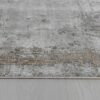 Gray and beige textured area rug on wooden floor