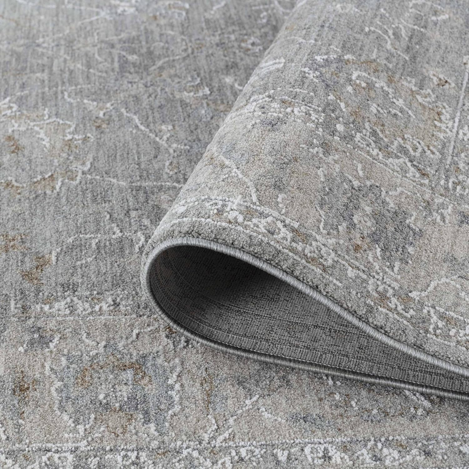 Gray patterned rug with folded corner detail