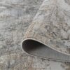 Rolled up textured gray and beige rug