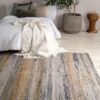 Cozy bedroom with bed, patterned rug, and plant