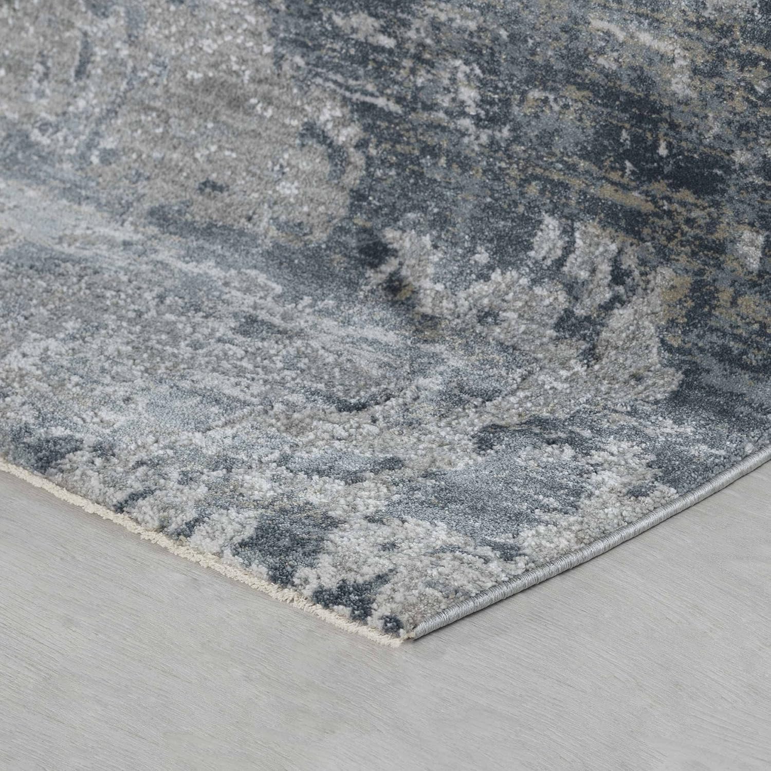 Gray textured rug on light wooden floor.