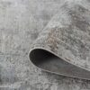 Gray textured rug with folded corner