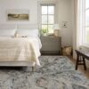 Cozy bedroom with neutral decor and large window.