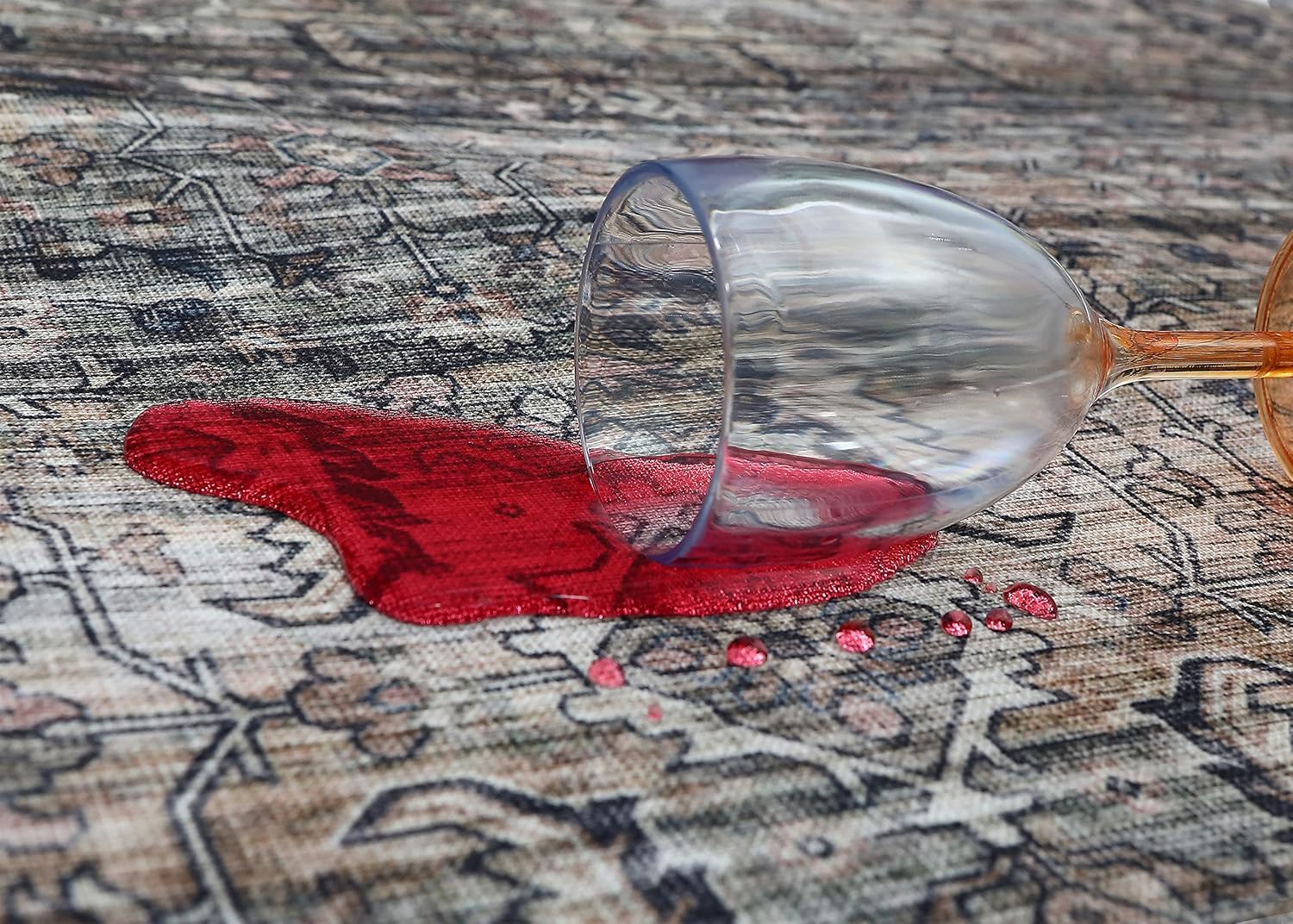 Spilled wine glass on patterned rug.
