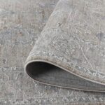 Beige patterned area rug rolled corner