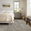 Cozy bedroom with neutral decor and large window.