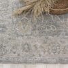 Gray decorative rug with woven basket and pampas grass.