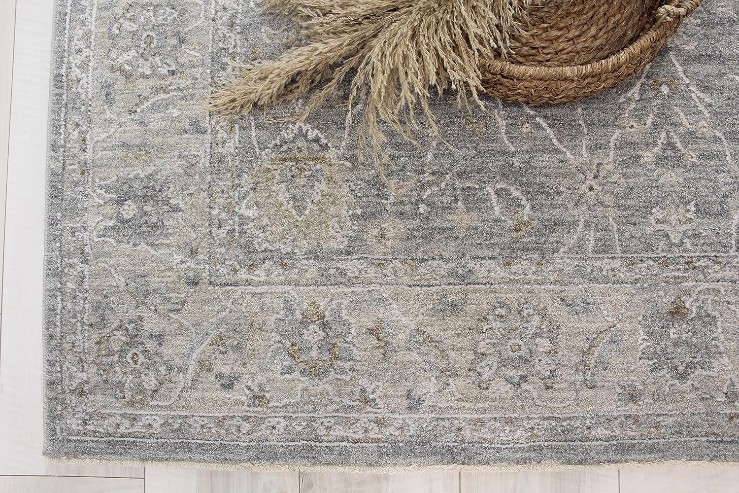 Gray decorative rug with woven basket and pampas grass.