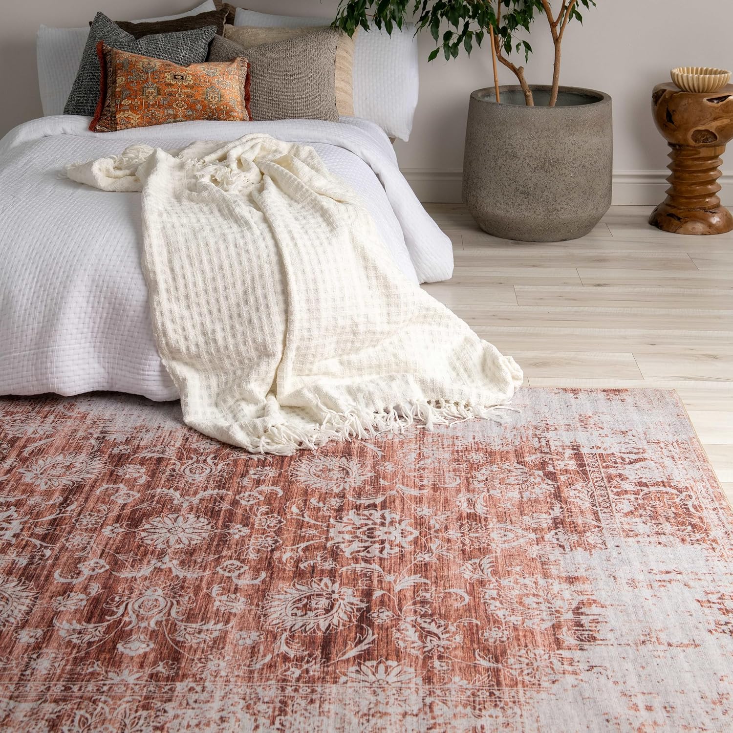 Cozy bedroom with stylish rug and plush bedding.