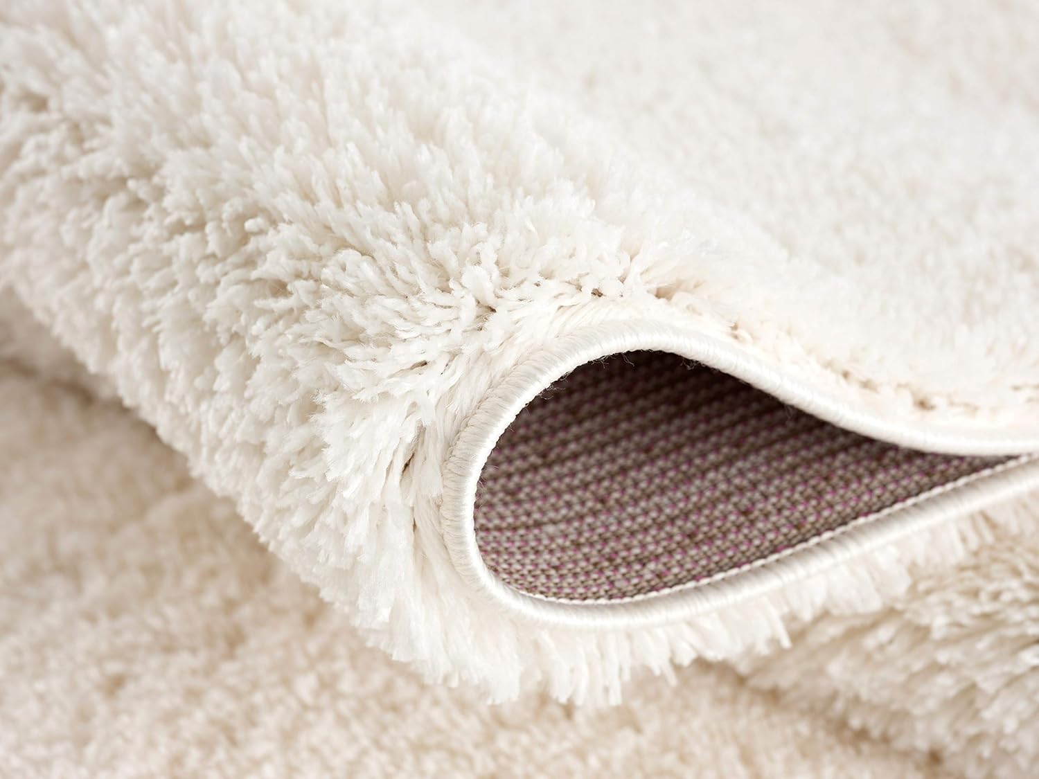 Close-up of fluffy white carpet corner.