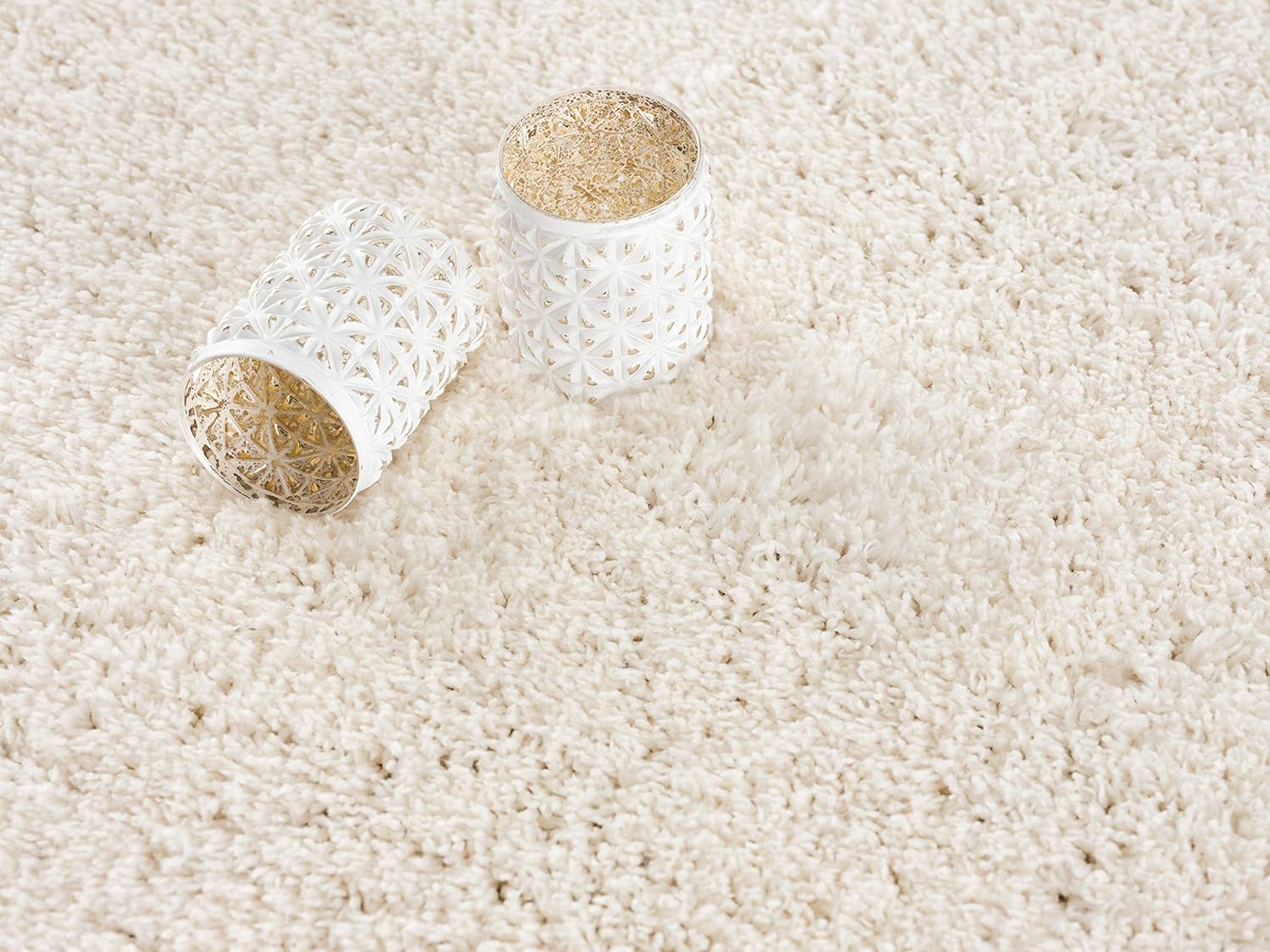 White candles on textured cream rug