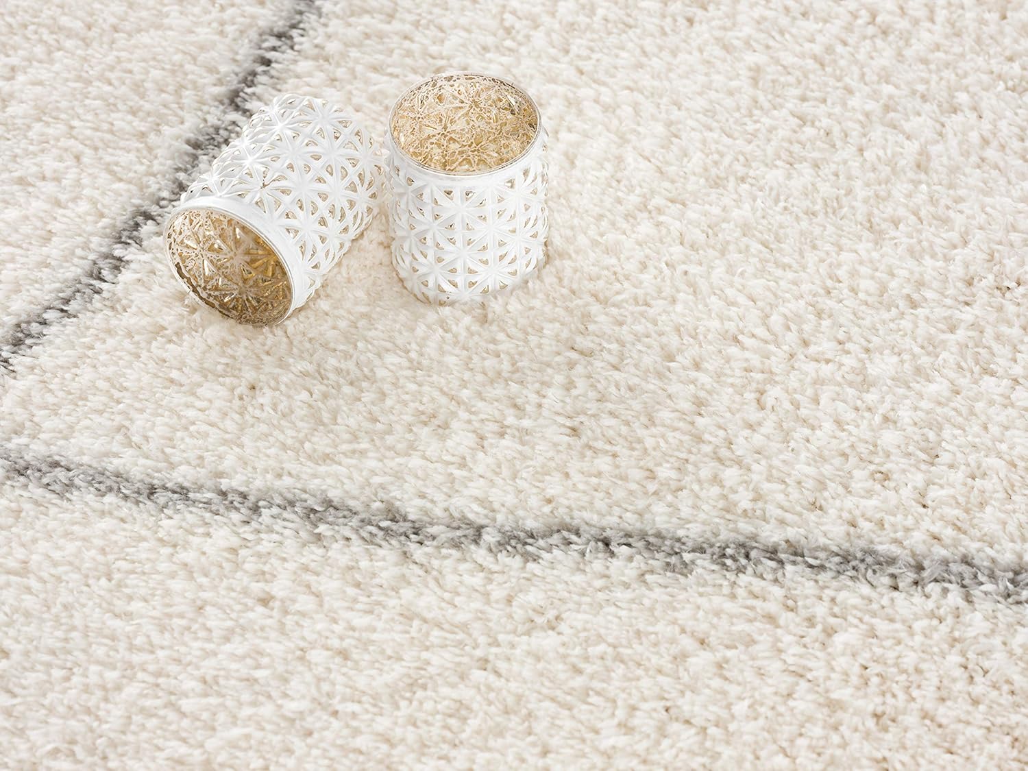 Two decorative candle holders on a carpet