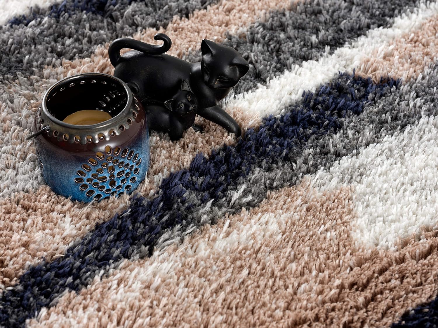 Decorative candleholder on patterned shaggy rug background.