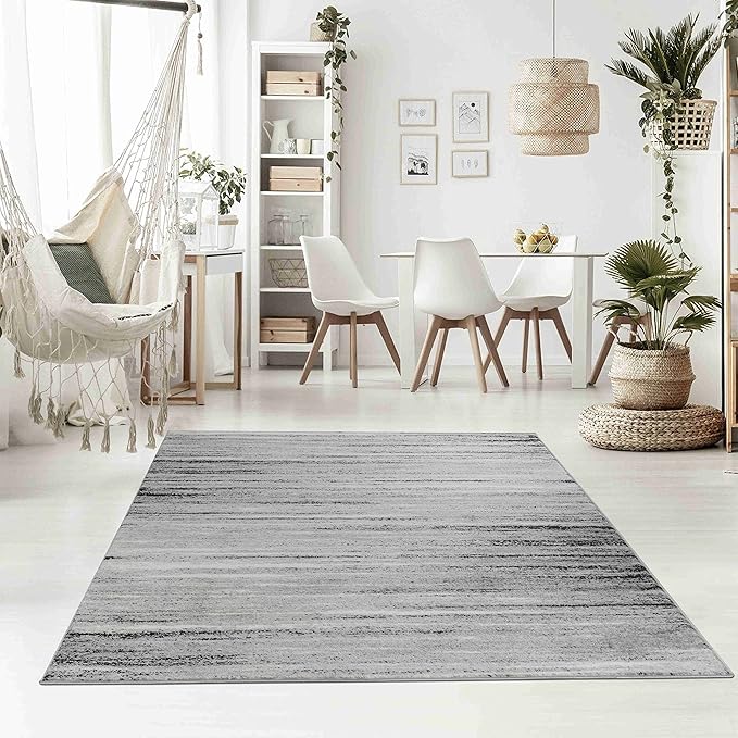 Modern living room with dining area and gray rug.