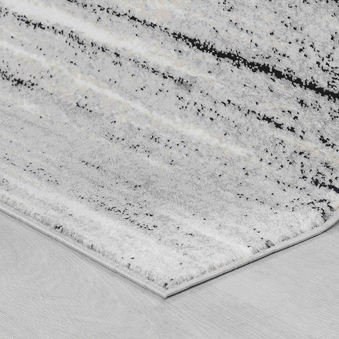 Gray and white rug on wooden floor