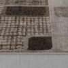 Textured geometric patterned rug on wood floor.