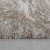 Beige and white textured rug on wooden floor.