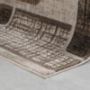 Corner of brown geometric pattern rug on floor.