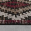 Geometric patterned rug on gray wooden floor.
