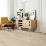 Modern living room with plants and yellow chair.