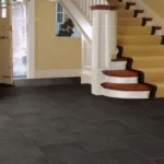 Modern home entrance with black tiled floor.