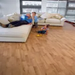 Family playing in living room with wood flooring.